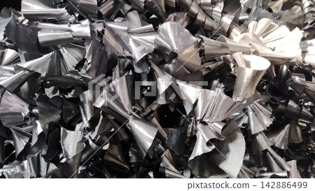 Steel scrap materials recycling. Aluminum chip waste after machining metal parts on a cnc lathe. Closeup twisted spiral steel shavings. Small roughness sharpness, 142886499