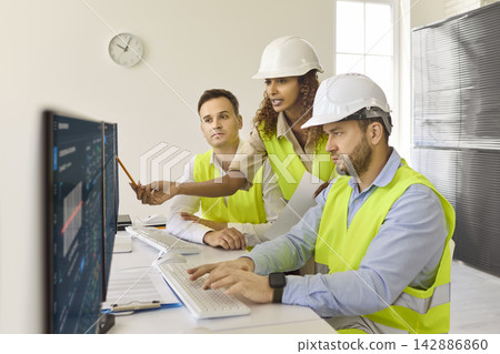 Team of engineers analyzing production data on screens in modern control room Team of engineers analyzing production data on screens in modern control room 142886860