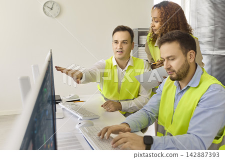 Industrial Engineers Overseeing Operations at Monitors in Secure Control Room Industrial Engineers Overseeing Operations at Monitors in Secure Control Room 142887393