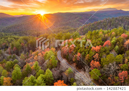 Road trip in fall season through Appalachian forest in Tennessee. Car driving on a winding road under colorful autumn canopy Road trip in fall season through Appalachian forest in Tennessee. Car driving on a winding road under colorful autumn canopy 142887421