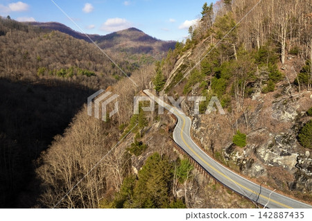 Highlands Road mountain highway in North Carolina during fall. Driving through forested hills and rocky ridgelines under colorful trees. Highlands Road mountain highway in North Carolina during fall. Driving through forested hills and rocky ridgelines under colorful trees. 142887435