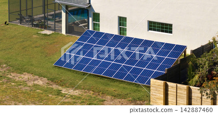 Autonomous house with solar photovoltaic panels mounted on stand-alone frame on backyard ground for generating of clean ecological electric energy Autonomous house with solar photovoltaic panels mounted on stand-alone frame on backyard ground for generating of clean ecological electric energy 142887460
