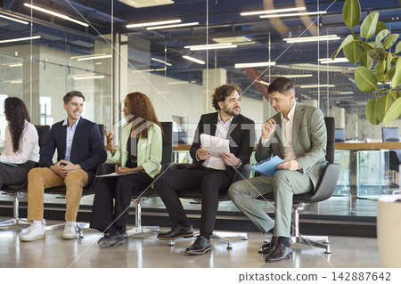 Diverse business team networking in office lobby before corporate seminar Diverse business team networking in office lobby before corporate seminar 142887642