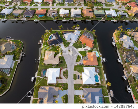 Evening light over Florida waterfront community. Expensive homes and luxury mansions illuminated by sundown sky. 142887643