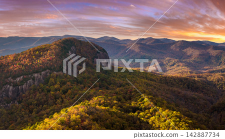 Autumn woods in Pisgah National Forest around Looking Glass Rock in North Carolina Appalachian mountains at colorful sundown. Bright yellow foliage on mountain slopes. Autumn woods in Pisgah National Forest around Looking Glass Rock in North Carolina Appalachian mountains at colorful sundown. Bright yellow foliage on mountain slopes. 142887734