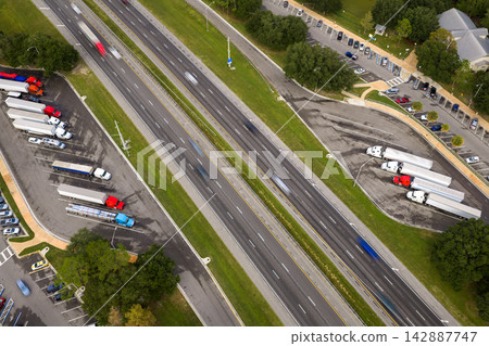 Truck stop at state welcome center near busy American interstate freeway. Parking for semi-trucks during interstate travel. Truck stop at state welcome center near busy American interstate freeway. Parking for semi-trucks during interstate travel. 142887747