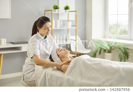 Spa therapist giving relaxing massage to shoulders of client in skincare clinic Spa therapist giving relaxing massage to shoulders of client in skincare clinic 142887956