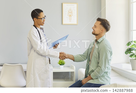Doctor and patient shaking hands after consultation in a bright modern clinic Doctor and patient shaking hands after consultation in a bright modern clinic 142887988