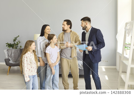 Happy family meeting realtor at new home, father shaking hands with agent indoors Happy family meeting realtor at new home, father shaking hands with agent indoors 142888308