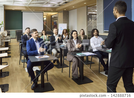 Business team applauding speaker after seminar presentation in modern office 142888716