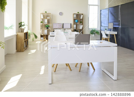 Bright modern classroom interior with white desks, laptops and tall windows Bright modern classroom interior with white desks, laptops and tall windows 142888896