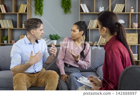 Interracial couple arguing in counseling session with therapist resolving issues Interracial couple arguing in counseling session with therapist resolving issues 142888897