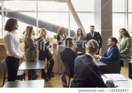 Diverse business team standing in office for training discussion and strategy briefing Diverse business team standing in office for training discussion and strategy briefing 142888941