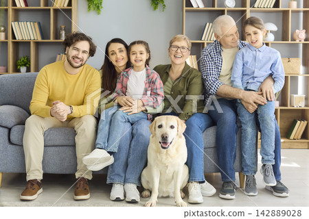 Happy multigenerational family with labrador sitting at home, cheerful portrait Happy multigenerational family with labrador sitting at home, cheerful portrait 142889028