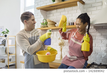 Happy couple cleaning kitchen together, fun teamwork and domestic hygiene Happy couple cleaning kitchen together, fun teamwork and domestic hygiene 142889042