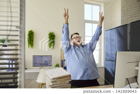Happy overweight office worker dancing by computer, financial analysis success Happy overweight office worker dancing by computer, financial analysis success 142889043