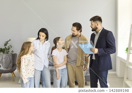 Smiling family consulting with real estate agent about new home purchase indoors Smiling family consulting with real estate agent about new home purchase indoors 142889198