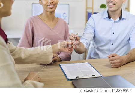 Happy couple meeting financial advisor to sign bank contract and finalize mortgage Happy couple meeting financial advisor to sign bank contract and finalize mortgage 142889592