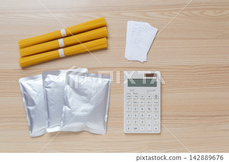 An image of food stockpiling and household budget/food expense management, showing emergency food supplies, receipts, and a calculator laid out. An image of food stockpiling and household budget/food expense management, showing emergency food supplies, receipts, and a calculator laid out. 142889676