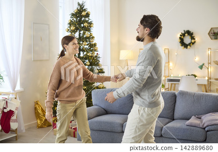 Christmas couple dancing at home, celebrating winter season with dance at home Christmas couple dancing at home, celebrating winter season with dance at home 142889680