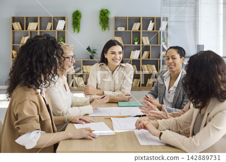 Diverse business women team meeting and collaboration around modern office desk Diverse business women team meeting and collaboration around modern office desk 142889731