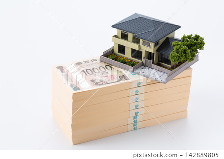 A stack of 7 million yen bills and a model house A stack of 7 million yen bills and a model house 142889805