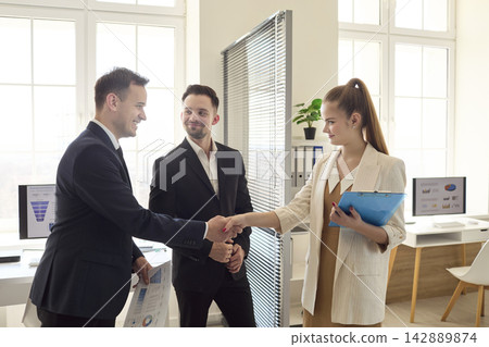 Handshake sealing partnership agreement between colleagues in modern office Handshake sealing partnership agreement between colleagues in modern office 142889874
