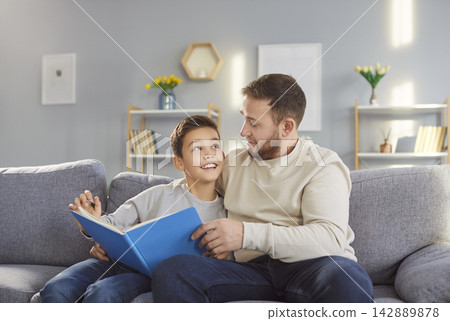 Father and son, happy loving family reading book at home, young parent with cute little child 142889878