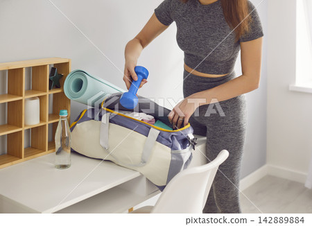 Close Up Of Woman Packing Sports Bag With Training Equipment Close Up Of Woman Packing Sports Bag With Training Equipment 142889884