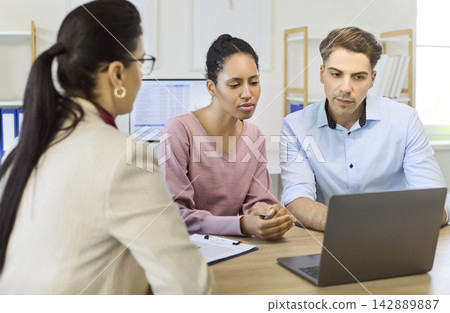 Couple meeting a financial advisor to discuss loan approval, mortgage planning Couple meeting a financial advisor to discuss loan approval, mortgage planning 142889887