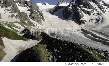 Aerial view of snow covered mountain peaks under a clear blue winter sky . Media Aerial view of snow covered mountain peaks under a clear blue winter sky . Media 142890202