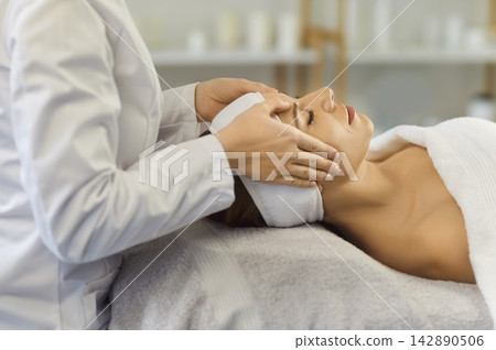 Cosmetologist, dermatologist or beautician doctor doing facial massage, cosmetic face procedure Cosmetologist, dermatologist or beautician doctor doing facial massage, cosmetic face procedure 142890506