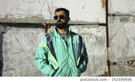 An Alone Asian Male In Sunglasses Against Textured Urban Backdrop With Sunlight Highlighting Details. Media An Alone Asian Male In Sunglasses Against Textured Urban Backdrop With Sunlight Highlighting Details. Media 142890696