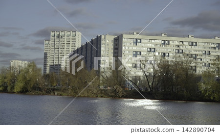 Serene Riverfront Scene. Peaceful Riverside Setting With Architecture And Cityscape Features. Creative Serene Riverfront Scene. Peaceful Riverside Setting With Architecture And Cityscape Features. Creative 142890704