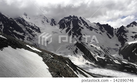 Aerial view of snow covered mountain peaks under a clear blue winter sky . Media Aerial view of snow covered mountain peaks under a clear blue winter sky . Media 142890746