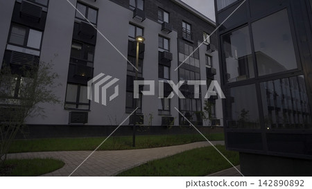 Calm Residential Garden Pathway Bathed In Gentle Amber Lighting And Reflective Glass Entrances. Stock Clip Calm Residential Garden Pathway Bathed In Gentle Amber Lighting And Reflective Glass Entrances. Stock Clip 142890892