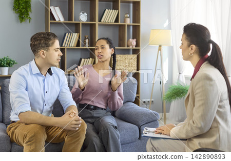 Therapist with couple in counseling session focused on conflict and communication Therapist with couple in counseling session focused on conflict and communication 142890893