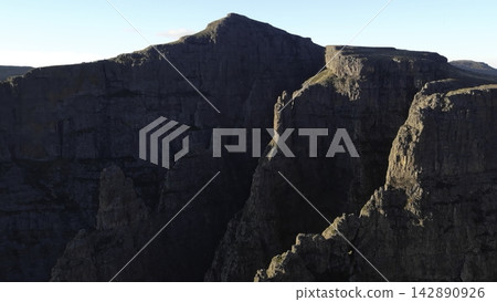 Rugged Rocky Mountain Cliff Under Clear Blue Sky . Media Rugged Rocky Mountain Cliff Under Clear Blue Sky . Media 142890926