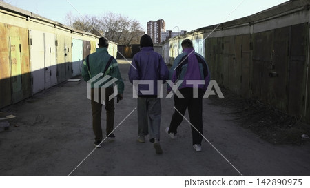 Group Of Three Walks Through Alleyway. Three Men Casually Journey Beneath Vibrant Blue Canopy. Media Group Of Three Walks Through Alleyway. Three Men Casually Journey Beneath Vibrant Blue Canopy. Media 142890975