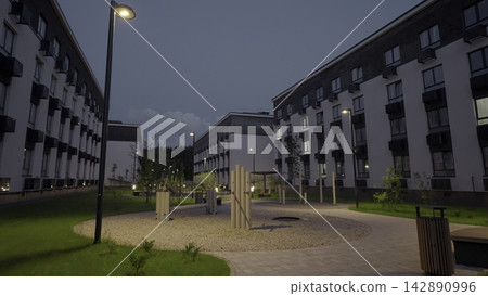 Evening Workout Area With Poles And Benches Amid Modern Buildings And Lit Winding Pathways. Stock Clip 142890996