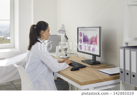 Doctor analyzing medical data on computer in clinic office, healthcare review Doctor analyzing medical data on computer in clinic office, healthcare review 142891029