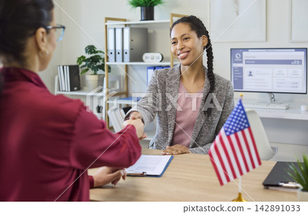 Immigration consultant shakes hands with client after visa approval success Immigration consultant shakes hands with client after visa approval success 142891033