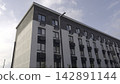 High Angle Shot Of Residential Facade. Tall Lamppost Beside Modern Brick Apartment With Blue Sky. Stock Clip 142891144