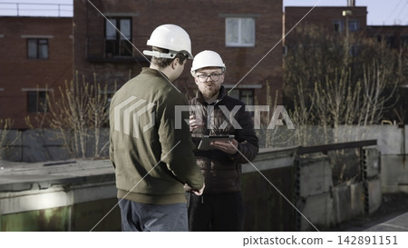 Engineers Inspect Roofs. Engineers Collaboratively Examine And Quantify Roof And Climate Control Systems. Media 142891151