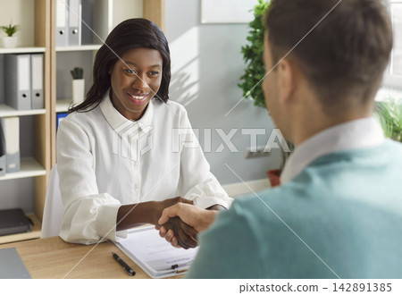 Hr manager shaking hands with new job candidate after successful interview in office. Hr manager shaking hands with new job candidate after successful interview in office. 142891385