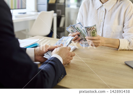 Closeup of employee receiving cash salary, payroll payment in modern office Closeup of employee receiving cash salary, payroll payment in modern office 142891438
