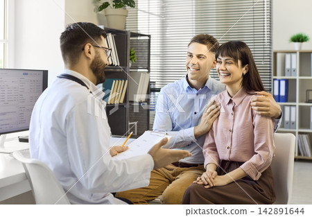 Smiling couple at doctor appointment discussing care options in clinic office Smiling couple at doctor appointment discussing care options in clinic office 142891644