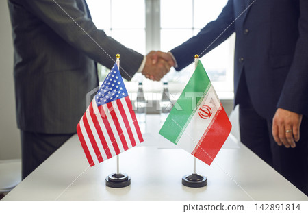 Handshake of Diplomats with US and Iran Flags Signaling Bilateral Peace Talks Handshake of Diplomats with US and Iran Flags Signaling Bilateral Peace Talks 142891814