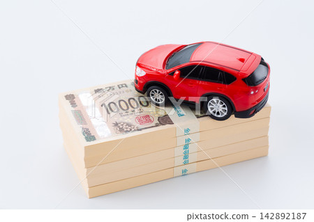 一疊500萬日元鈔票和一輛紅色汽車 142892187