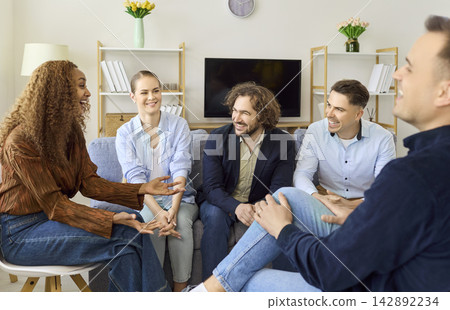 Young friends chatting and laughing at home during a relaxed social gathering 142892234